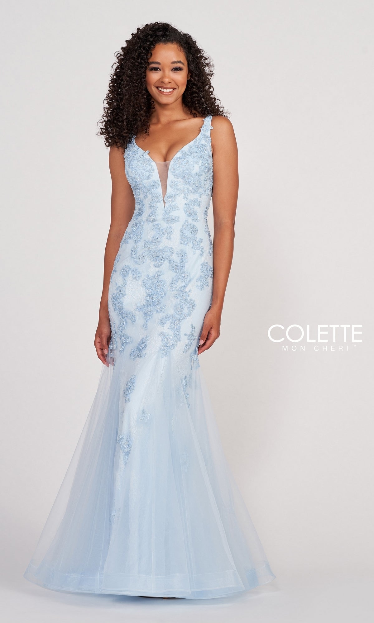 A woman wears the Light Blue Long Mermaid Prom Dress by Colette, featuring beaded lace details and a sheer skirt, standing against a plain background with the Colette for Mon Cheri logo on the right.